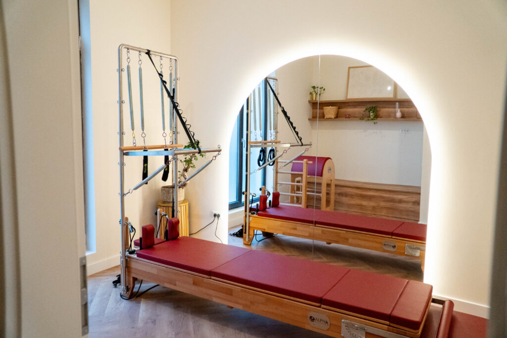 Sală privată de Pilates cu aparat Reformer și turn Cadillac, tapițerie bordo, la Bloom Pilates & Spa din Bragadiru